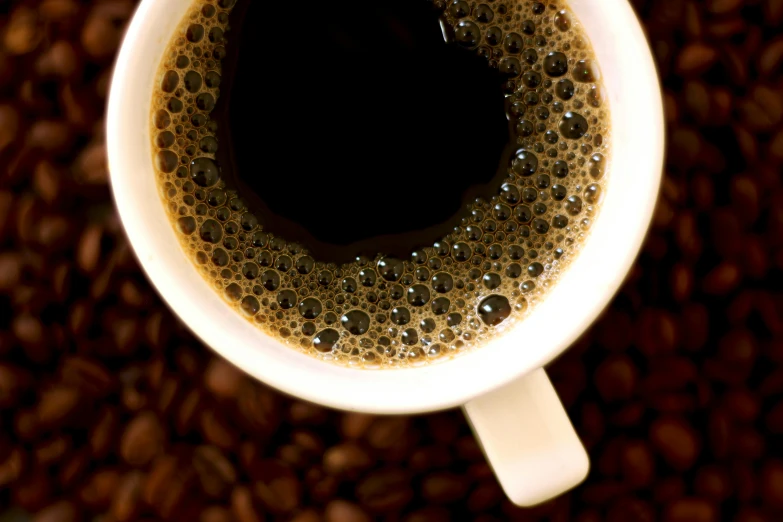 a cup of coffee sitting on top of a pile of coffee beans, pexels, renaissance, high angle close up shot, instagram photo, thumbnail, in 2 0 1 2