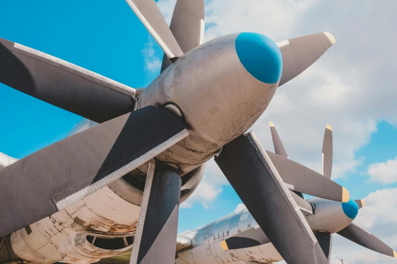 a large propeller plane sitting on top of a tarmac, pexels contest winner, modernism, large blue engines, view from below, avatar image