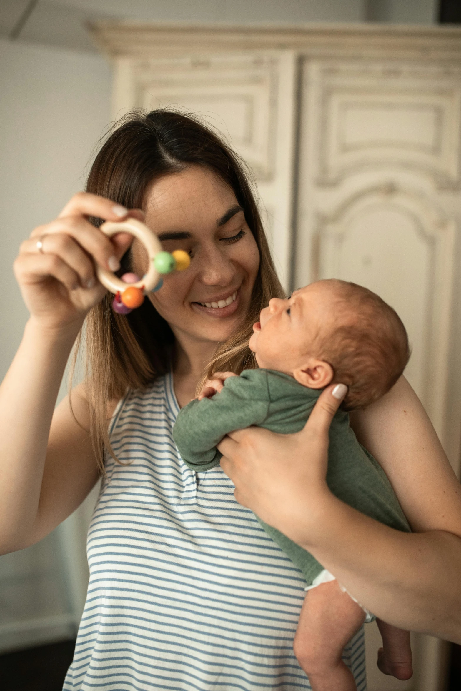 a woman holding a baby in her arms, pexels contest winner, the woman holds more toys, looping, face and upper - body focus, instagram post