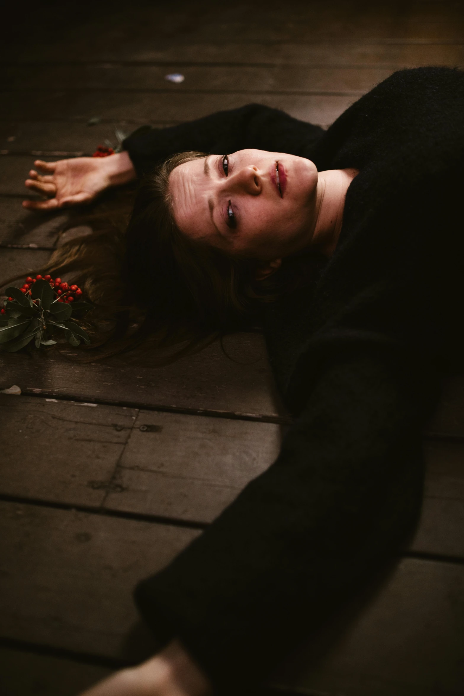 a woman laying on the floor with a flower in her hand, inspired by Elsa Bleda, pexels contest winner, renaissance, with a hurt expression, androgynous person, holiday season, ((portrait))