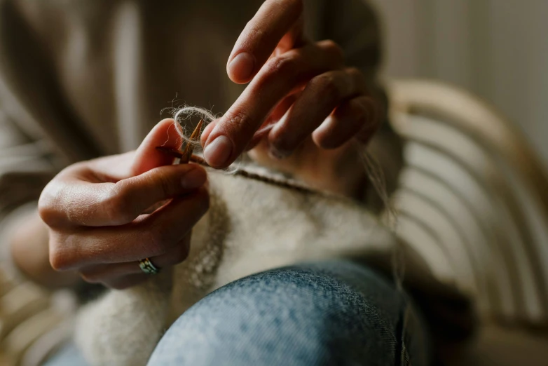 a close up of a person knitting a sweater, by Sylvia Wishart, trending on pexels, arts and crafts movement, nordic wedding ring, needle felting, a still of an ethereal, a small