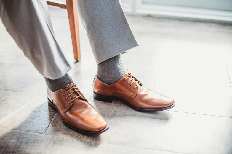 a close up of a person wearing brown shoes, inspired by Peter de Sève, ready for a meeting, light grey, rectangle, professionally made