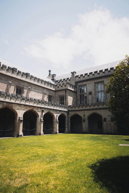 a large building sitting on top of a lush green field, inspired by Sydney Prior Hall, unsplash, renaissance, courtyard walkway, gothic library, slate, vendors