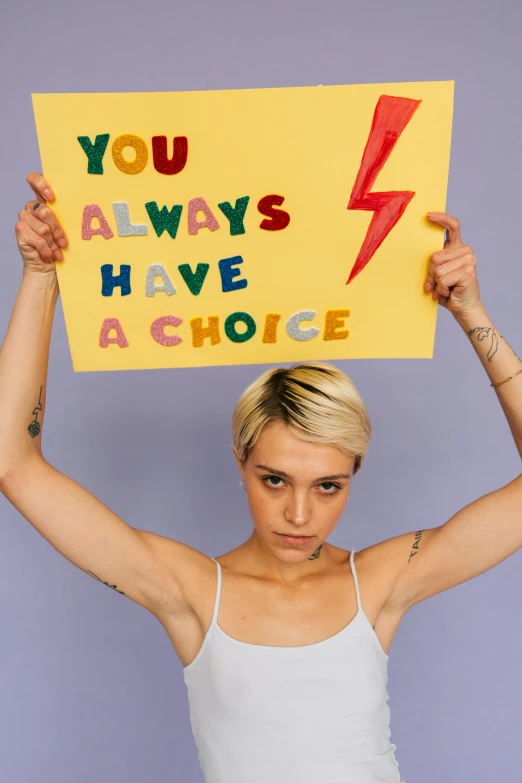 a woman holding a sign that says you always have a choice, a photo, trending on pexels, feminist art, short platinum hair tomboy, lesbian, lightening, okuda