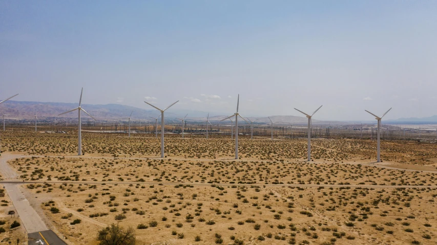 a group of wind turbines sitting in the middle of a desert, by Ryan Pancoast, fan favorite, highresolution, mundane, a green