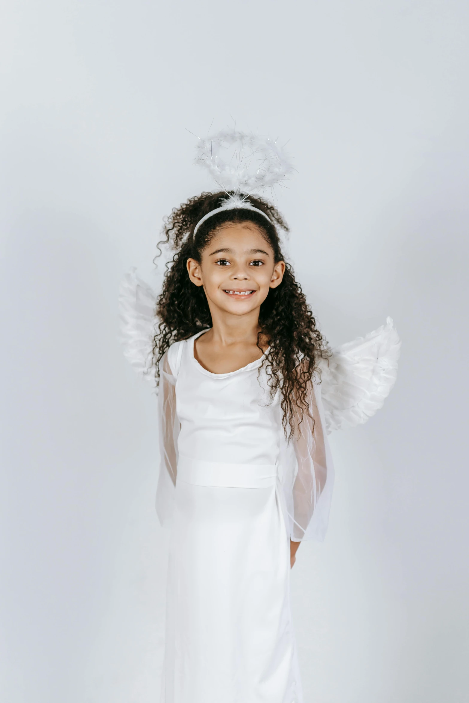 a little girl wearing a white dress and angel wings, inspired by Marie Angel, for junior, multiple, wearing festive clothing, diverse