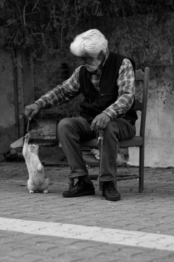 a man sitting on a bench next to a cat, a black and white photo, by Constantine Andreou, pexels contest winner, overalls and a white beard, a small, let's play, precious moments