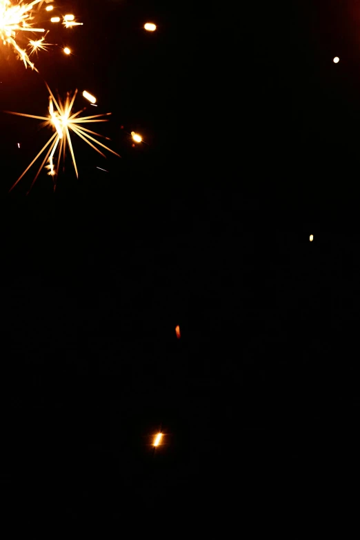 a close up of a person holding a sparkler, flickr, grainy low quality, square, [ fireworks in the sky ]!!, floating lanterns