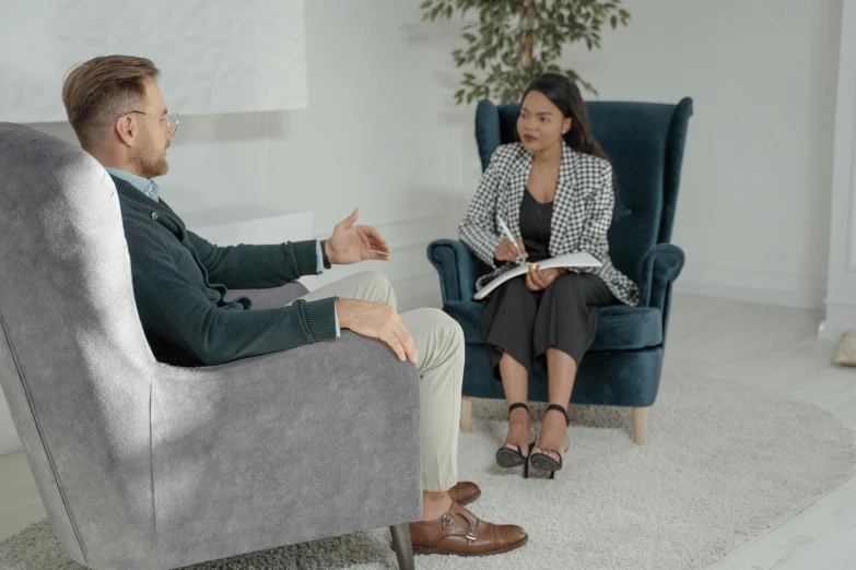 a woman sitting in a chair talking to a man, professional shot, low quality photo, animation still, professional image