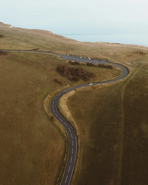an aerial view of a winding country road, an album cover, pexels contest winner, near the sea, thumbnail, high quality photo, construction