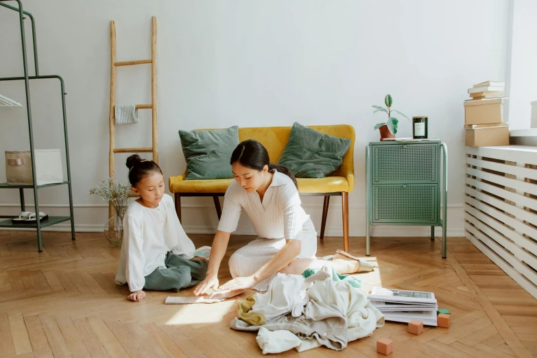 a woman and a child are sitting on the floor, pexels contest winner, minimalism, inspect in inventory image, white shirt and green skirt, furniture overturned, gif