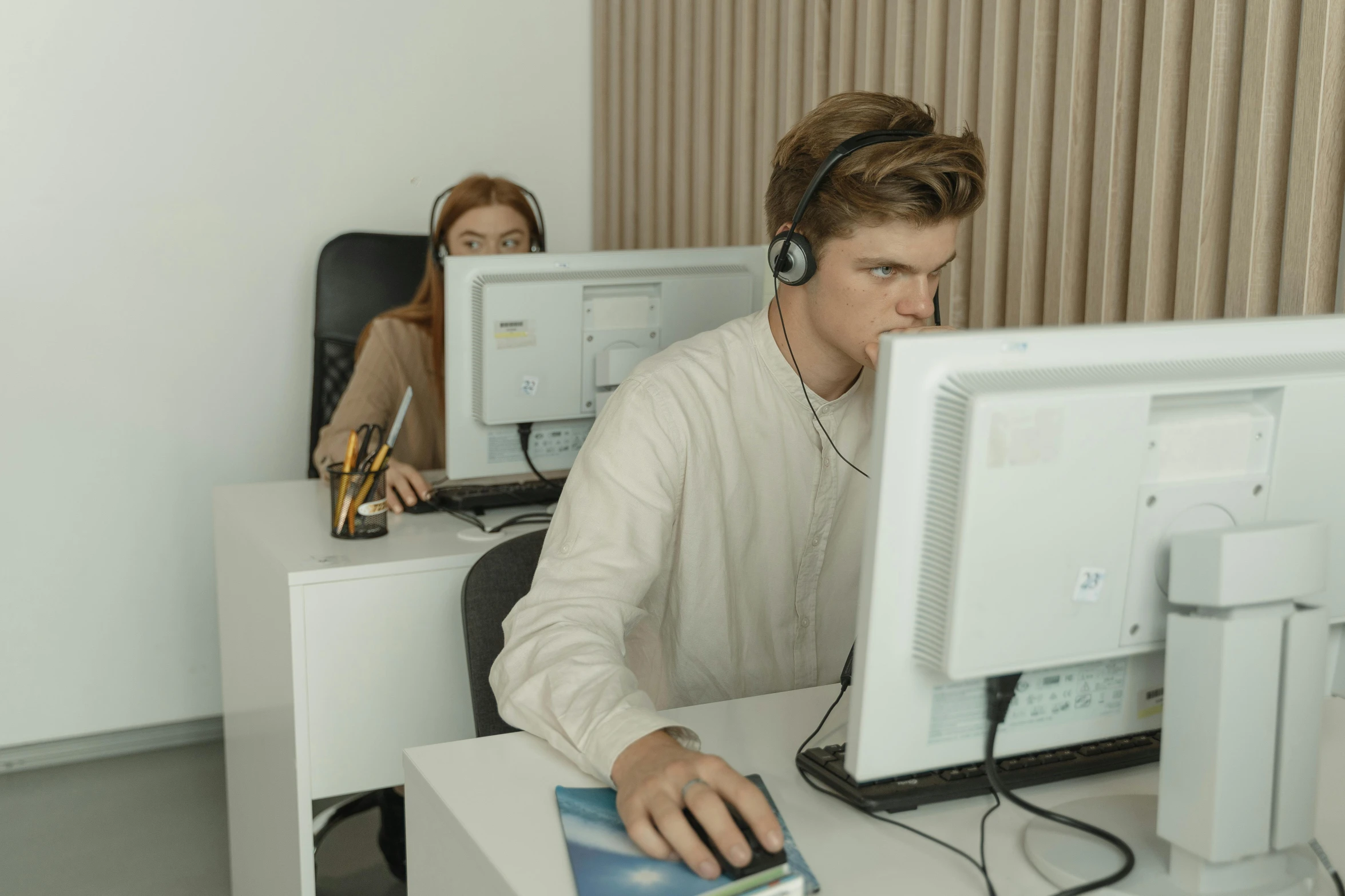 a man sitting at a desk in front of a computer, trending on pexels, two characters, wearing a headset, low quality photo, male teenager