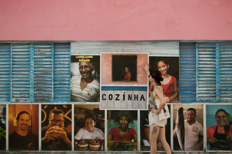 a woman walking down a sidewalk in front of a building, an album cover, inspired by Francis Souza, pexels contest winner, hyperrealism, amazon indian peoples in brazil, colorful signs, zochi, collages