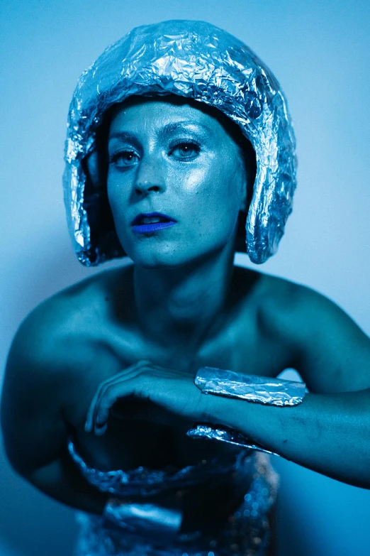 a woman with silver paint on her face, an album cover, inspired by Cindy Sherman, astronaut centaur, blue, headpiece, gray alien