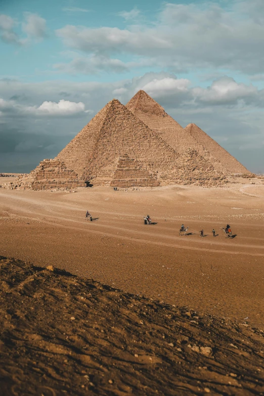 a group of people riding horses across a desert, egyptian art, pexels contest winner, ancient megastructure pyramid, nostalgic 8k, 🚿🗝📝, landscape photo