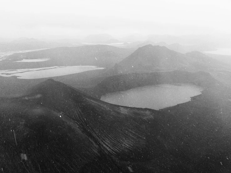 a black and white photo of a mountain range, land art, lakes, craters, photographic print, eerie atmospheric