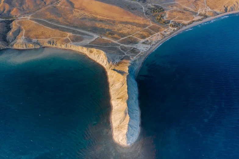 an aerial view of a large body of water, by Daren Bader, pexels contest winner, land art, chalk cliffs above, greek nose, nekro petros afshar, realistic image