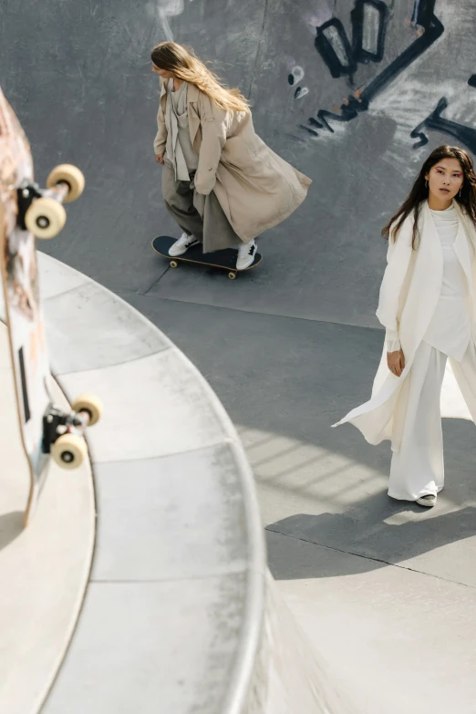 a group of people riding skateboards at a skate park, by Emma Andijewska, renaissance, wearing long white robe, asian woman, issey miyake, ultrawide cinematic