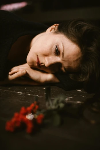 a woman laying on top of a wooden table, a portrait, pexels contest winner, renaissance, flowers in her dark hair, pensive and hopeful expression, concert, close-up portrait film still
