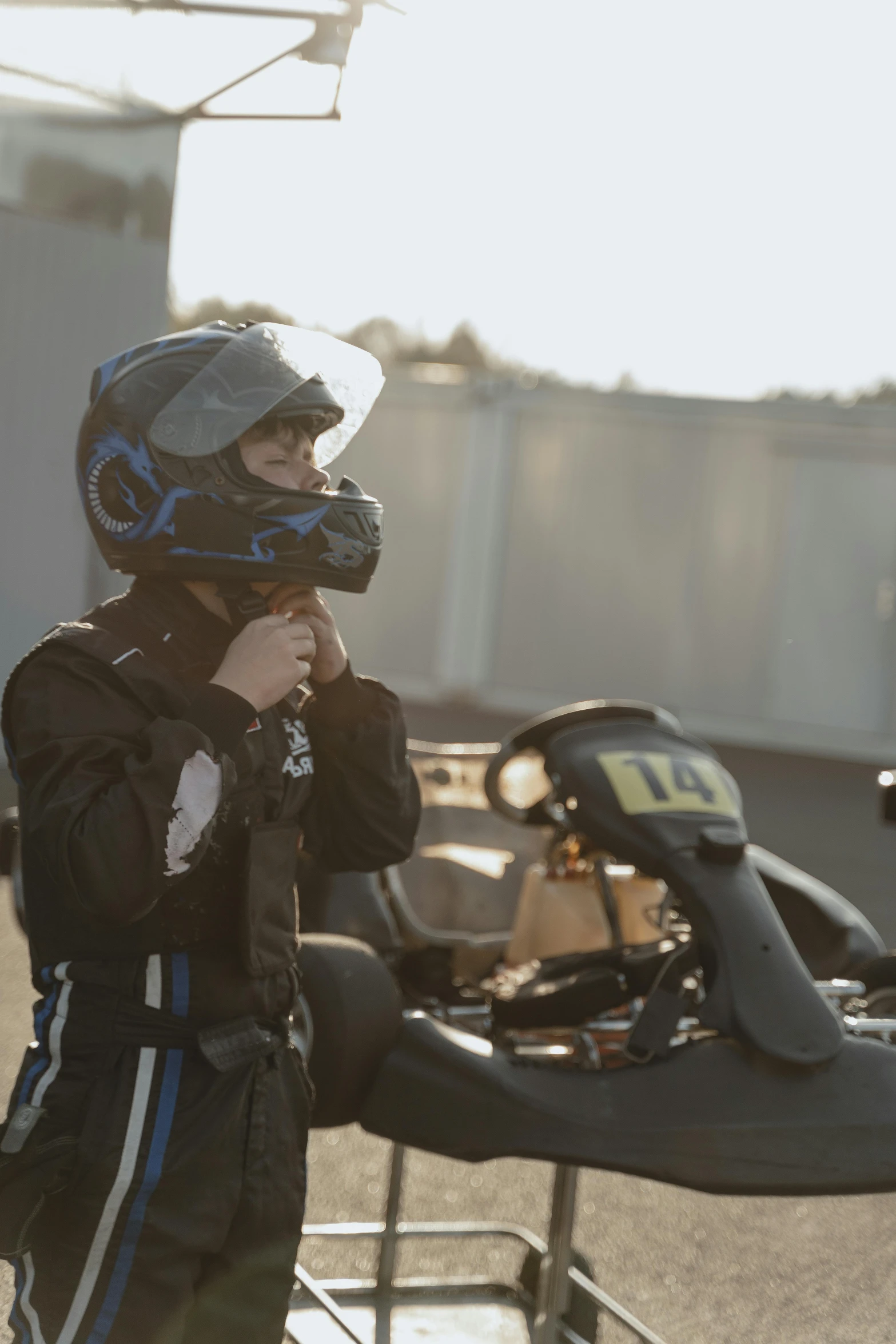 a person standing next to a motorcycle with a helmet on, formula 1, black, square, kids