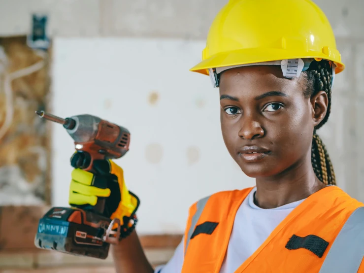 a woman in a hard hat holding a drillet, inspired by Afewerk Tekle, pexels contest winner, screwdriver, young black woman, a brightly coloured, blippi