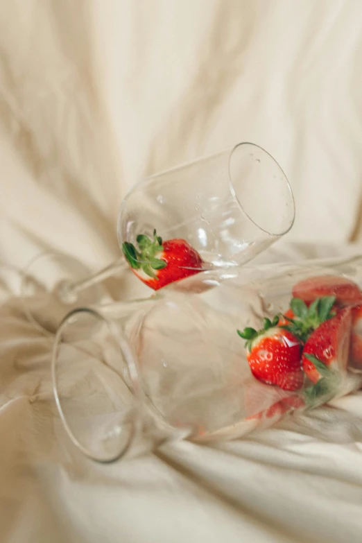 two empty wine glasses with strawberries in them, unsplash, romanticism, laying in bed, made of glazed, picnic, alternate angle