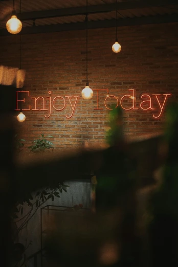 a brick wall with a neon sign that says enjoy today, by Anna Findlay, unsplash contest winner, in a coffee shop, late evening, holiday, looking happy