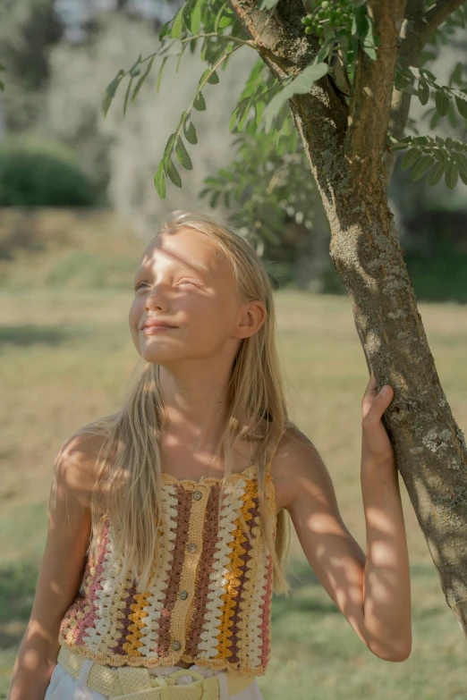 a little girl that is standing under a tree, sunbathed skin, still from a live action movie, young southern woman, portrait featured on unsplash