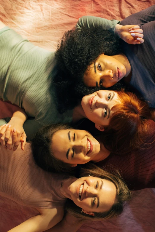 a group of women laying on top of a bed, inspired by Nan Goldin, trending on pexels, renaissance, redhead woman, high angle closeup portrait, happy cozy feelings, still image from tv series