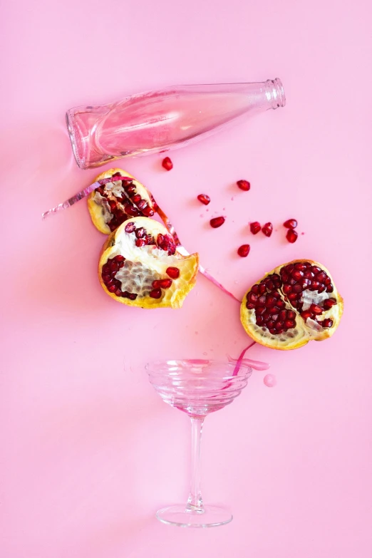 pomegranates and a wine glass on a pink background, by Julia Pishtar, trending on pexels, made of drink, jelly, battered, lemonade