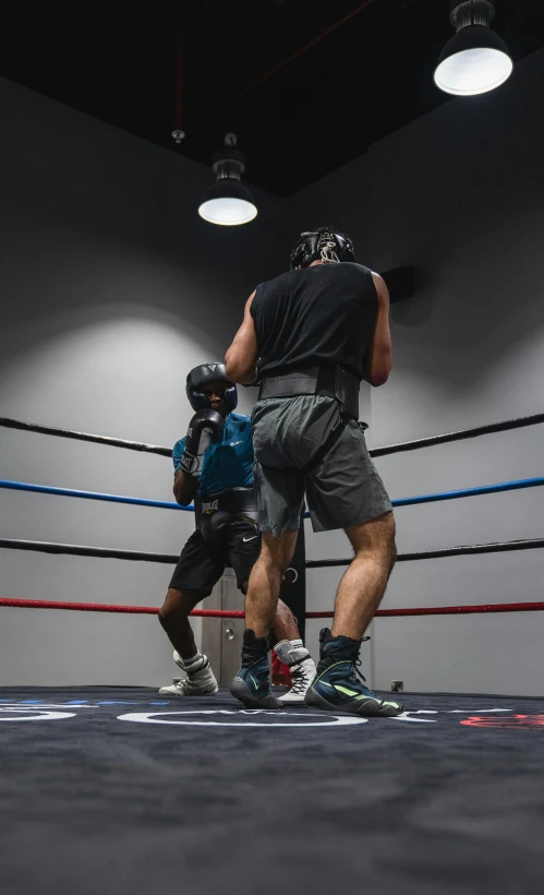 a couple of men standing next to each other in a boxing ring, by Robbie Trevino, usa-sep 20, low quality photo, dynamic action shot, helmet view