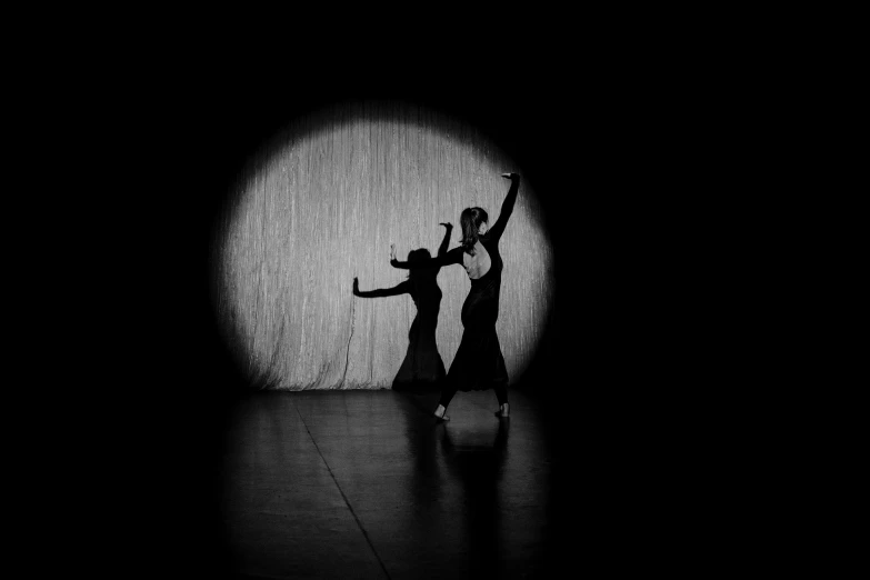 a couple of people that are standing in the dark, a black and white photo, by Zoltán Joó, pixabay, conceptual art, ballet performance photography, circle, ball, fabric