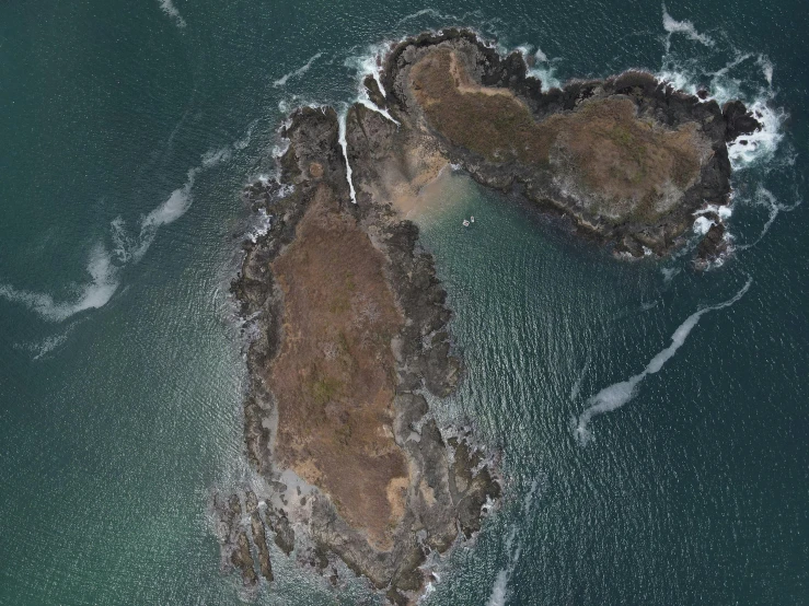 a couple of rocks in the middle of a body of water, satelite imagery, on an island, offshore winds, listing image