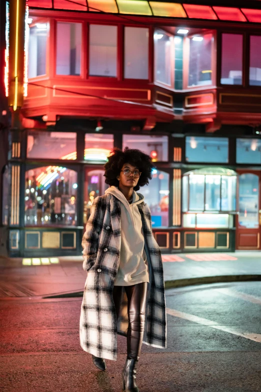 a woman standing in the middle of a street at night, willow smith zendaya, san francisco, flannel, warm street lights store front