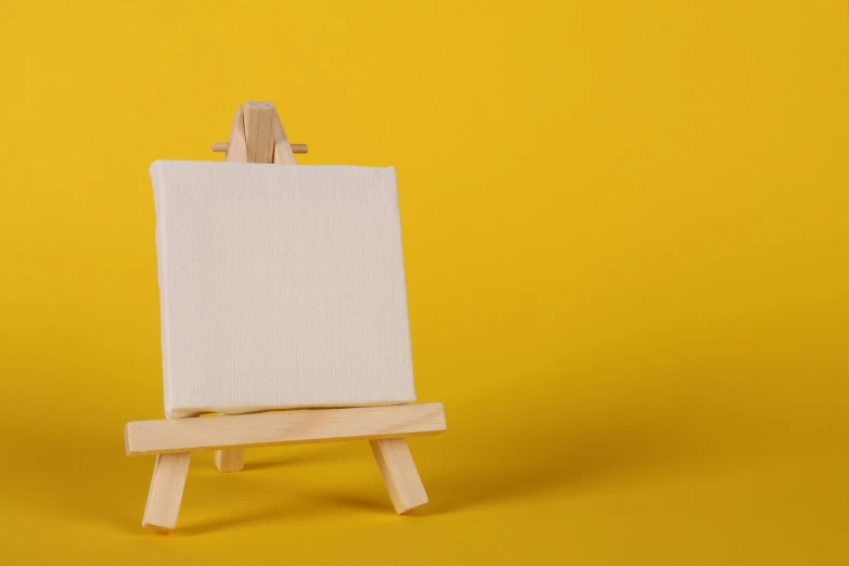 an easel with a blank canvas on a yellow background, by artist, pexels contest winner, visual art, square, white color, small, 4k artwork