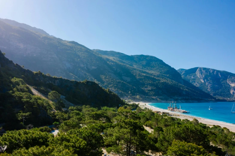 a view of a beach from the top of a hill, by Alexis Grimou, mount olympus, trees and cliffs, mountainous setting, conde nast traveler photo