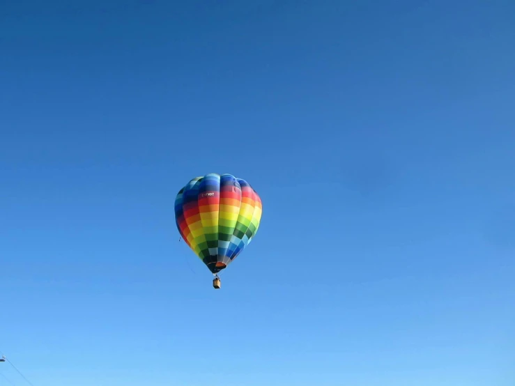 a colorful hot air balloon flying through a blue sky, a picture, by Jim Nelson, pexels contest winner, color field, cloudless blue sky, photo on iphone, deep blue sky, floating. greenish blue