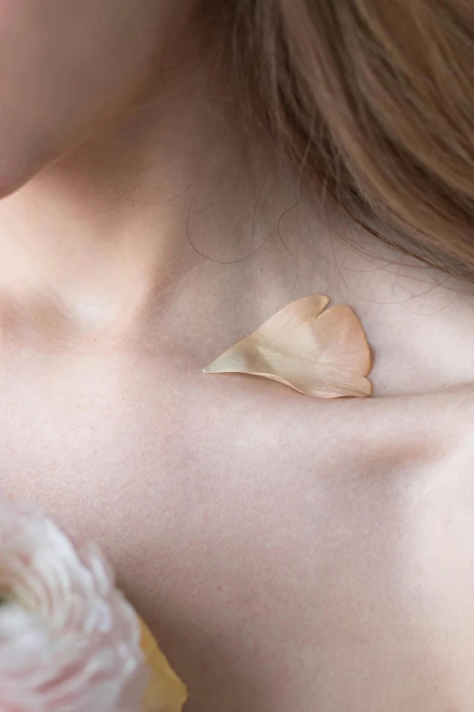 a close up of a woman with flowers on her chest, inspired by Méret Oppenheim, silicone skin, birch, white petal, rose gold heart