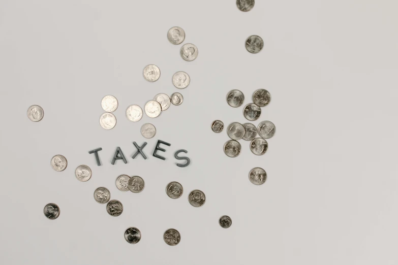 a pile of coins with the word taxes written on them, pexels, conceptual art, sparse floating particles, 3 4 5 3 1, alessio albi, on a pale background