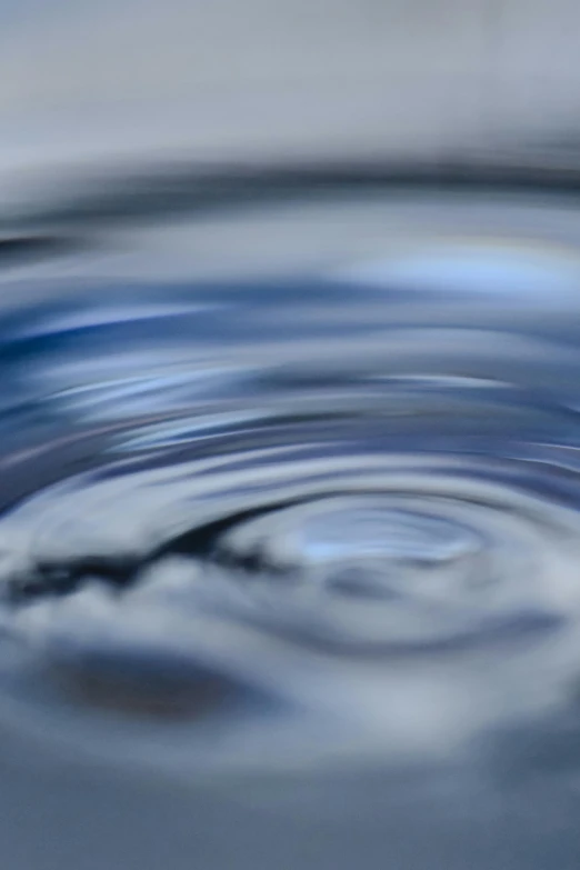 a close up of a water drop in a pool, swirly lunar ripples, shades of blue and grey, overflowing energy, vibration