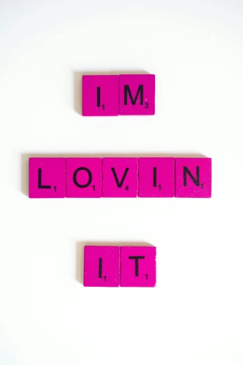 pink scrabbles spelling i'm lovin it on a white surface, an album cover, inspired by Dan Luvisi, trending on unsplash, letterism, 2 5 6 x 2 5 6 pixels, loving, panel, society 6