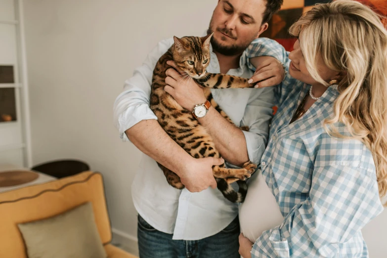 a man standing next to a woman holding a cat, by Julia Pishtar, pexels contest winner, pregnant belly, lachlan bailey, avatar image, 2717433015