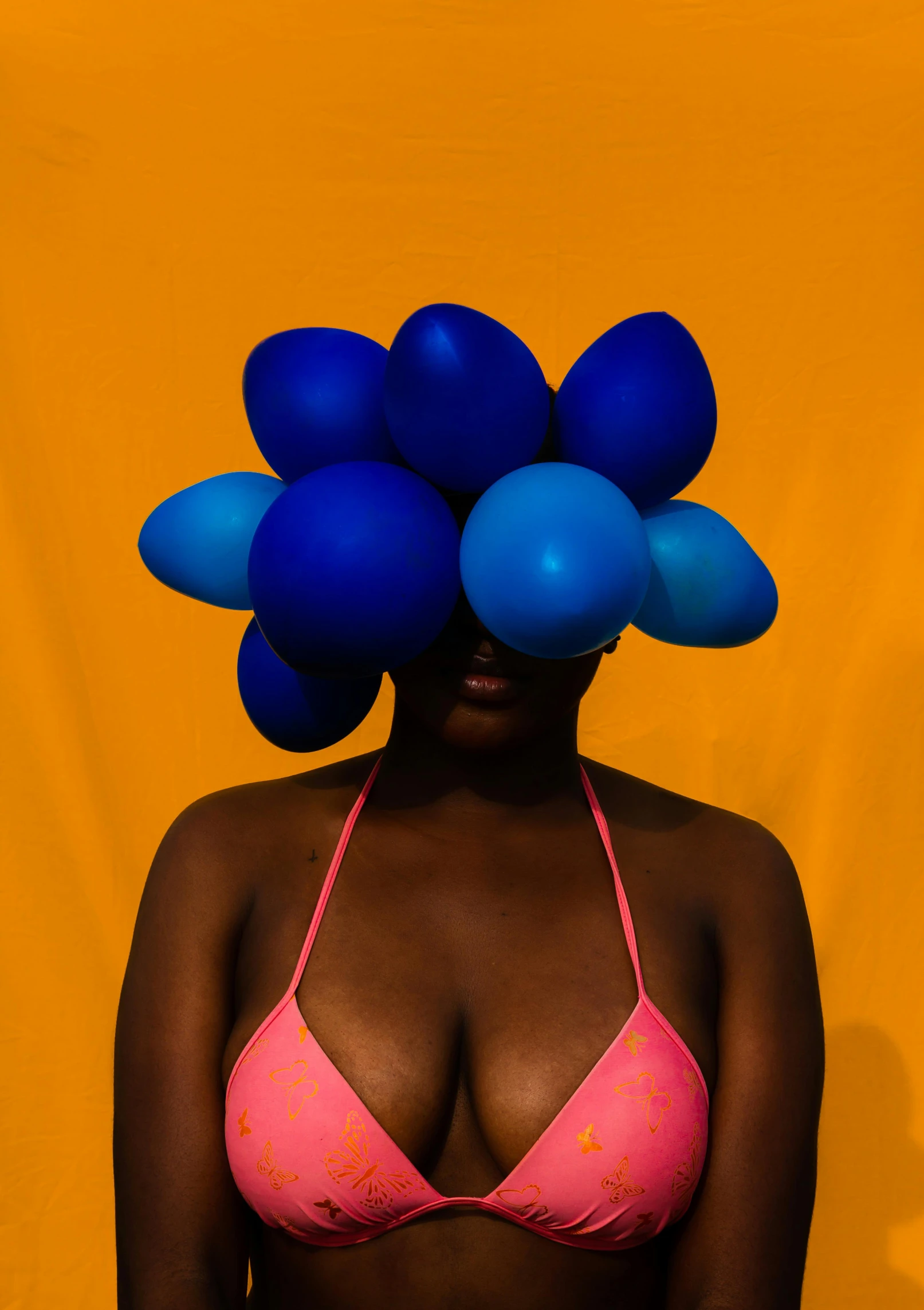 a woman in a bikini with a bunch of balloons on her head, inspired by Barkley Hendricks, unsplash contest winner, afrofuturism, blue and orange color scheme, medium format color photography, abstract photography, color ( sony a 7 r iv