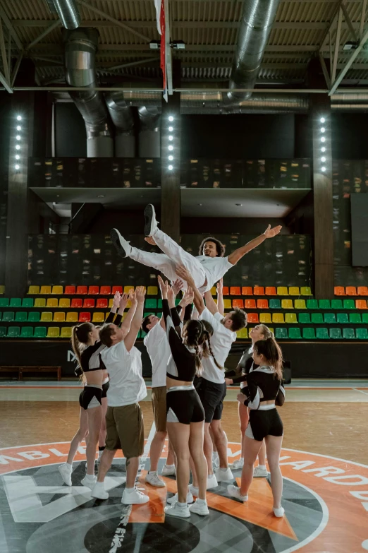 a group of young people standing on top of a basketball court, by Nina Hamnett, happening, acrobatic, promotional image, in the middle of an arena, an ahoge stands up on her head
