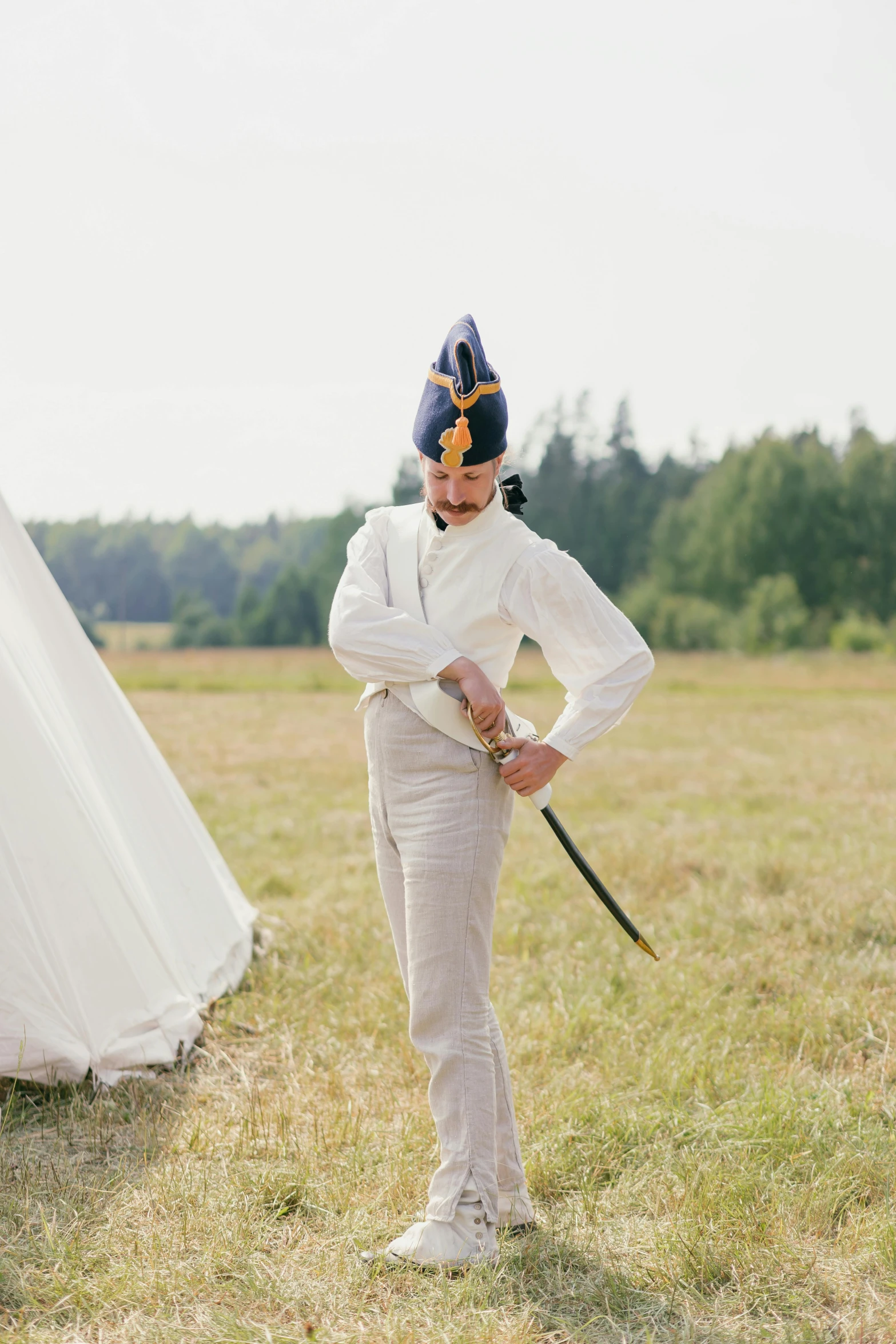 a man standing in a field next to a tent, by Grytė Pintukaitė, unsplash, renaissance, white uniform, getting ready to fight, dressed in a jodhpuri suit, finland