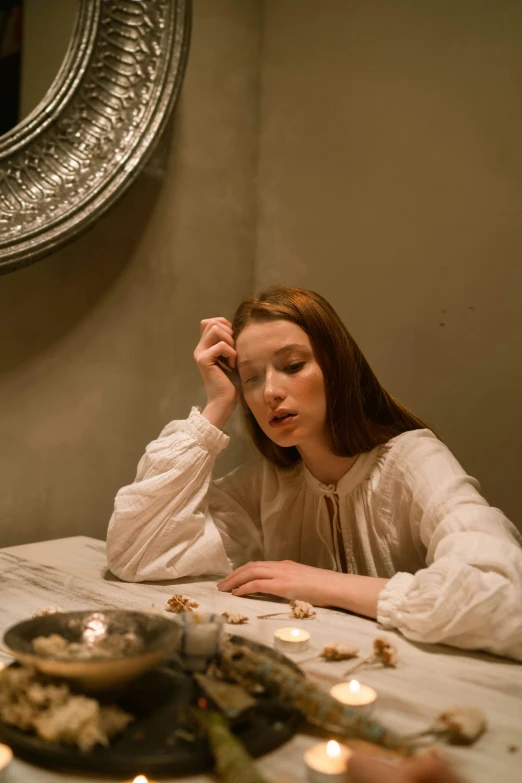 a woman sitting at a table with a plate of food, inspired by Georges de La Tour, pexels contest winner, renaissance, eleanor tomlinson, demna gvasalia, evening mood, ivory and copper