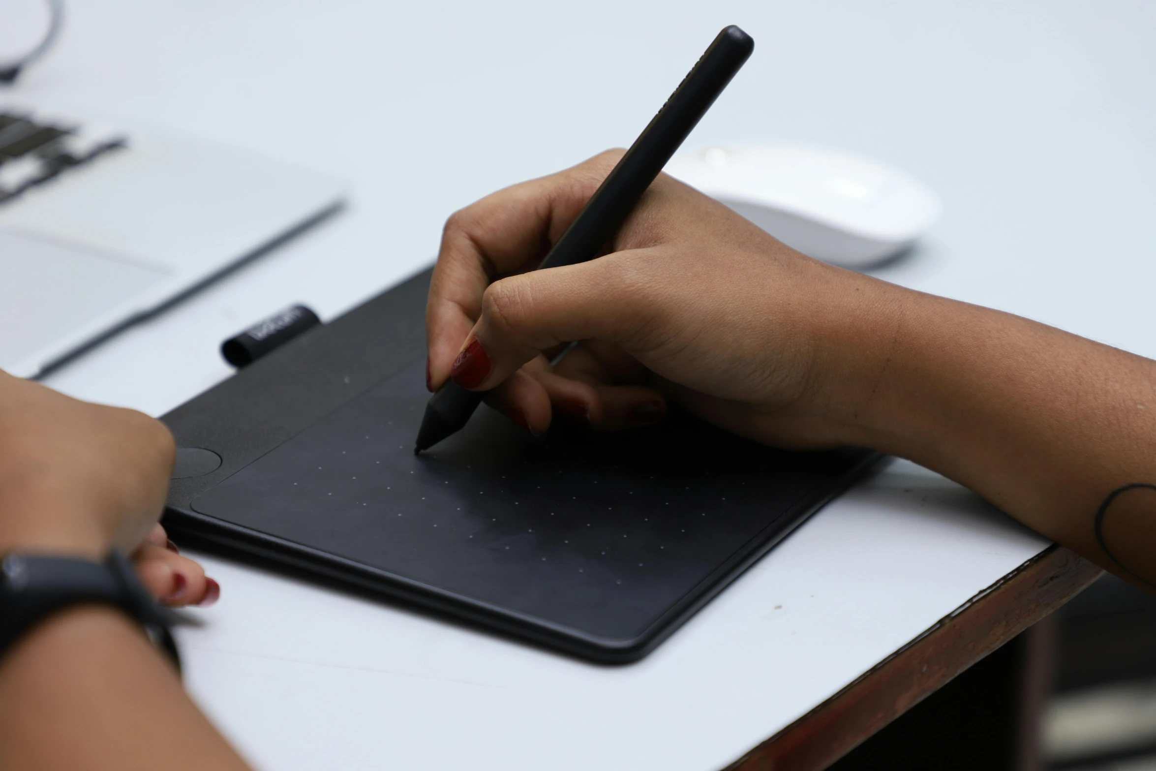 a person sitting at a desk with a pen in their hand, pexels contest winner, computer art, 9 9 designs, black matte finish, switch, digitally draw on wacom tablet