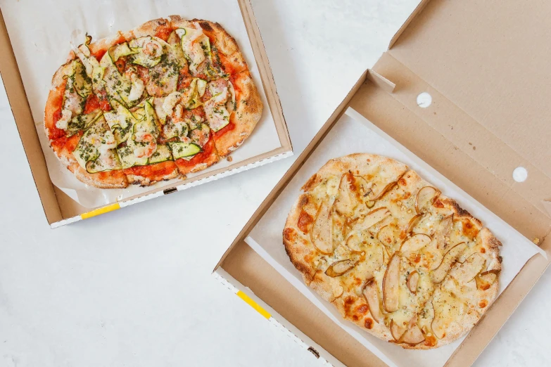 two boxes of pizza sitting on top of a table, flatlay, multi - coloured, 3 - piece, a blond