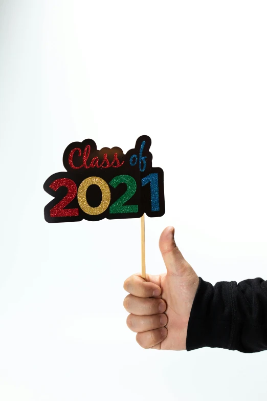 a person holding a sign that says class of 2021, a picture, glitter sticker, multi - coloured, medium-shot, cut out