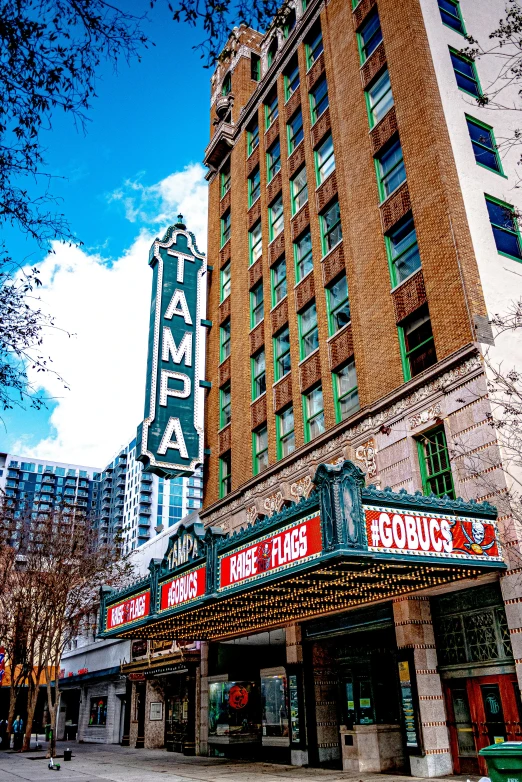 a theater marquee in front of a tall building, temples, in savannah, slide show, palms and miami buildings